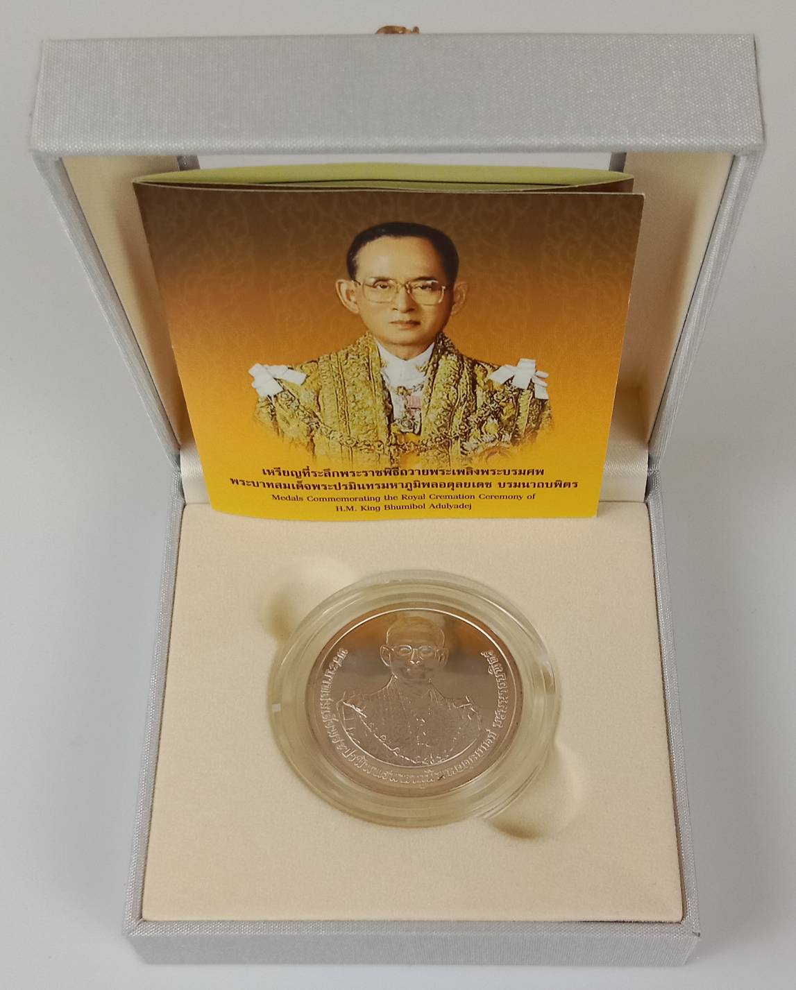 199.เหรียญเงินขัดเงาที่ระลึกในโอกาสการพระราชพิธีถวายพระเพลิงพระบรมศพพระบาทสมเด็จพระปรมินทรมหาภูมิพลอดุลยเดชบรมนาถบพิตร วันพฤหัสบดีที่ 26 ตุลาคม พุทธศักราช 2560 พร้อมใบเซอร์และกล่อง