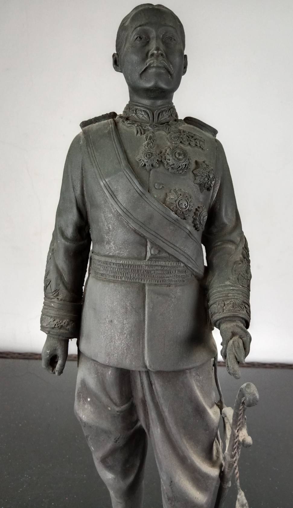 31.พระบรมรูปหล่อในหลวงรัชกาลที่5 พระบาทสมเด็จพระจุลจอมเกล้าเจ้าอยู่หัว ทรงยืนฉลองพระองค์ในราชปะแตนประดับเครื่องราชอิสริยาภรณ์ นุ่งผ้าโจงกระเบนสวมรองเท้าหุ้มส้น คาดพระแสงกระบี่